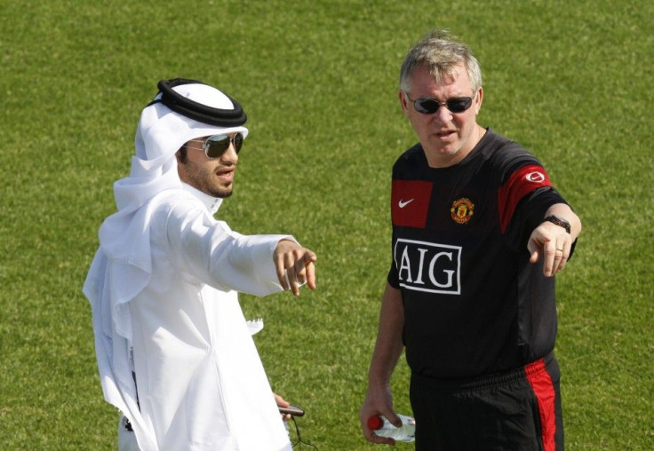 Manchester United's coach Alex Ferguson (R) talks to a facilities assistant during a training session at the Aspire Academy for Sports Excellence in Doha on Jan 2010.