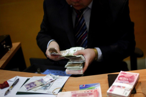 Employee counts Yuan currency at a local bank in Shanghai