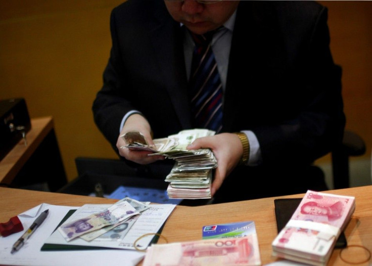 Employee counts Yuan currency at a local bank in Shanghai