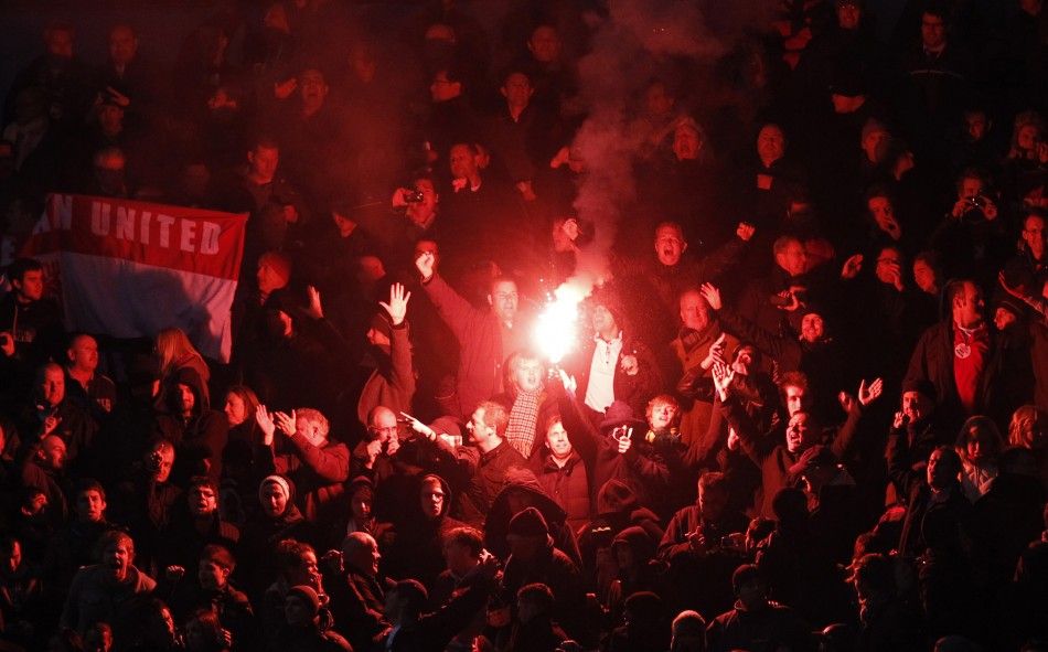 Manchester United fans hold up a flare.