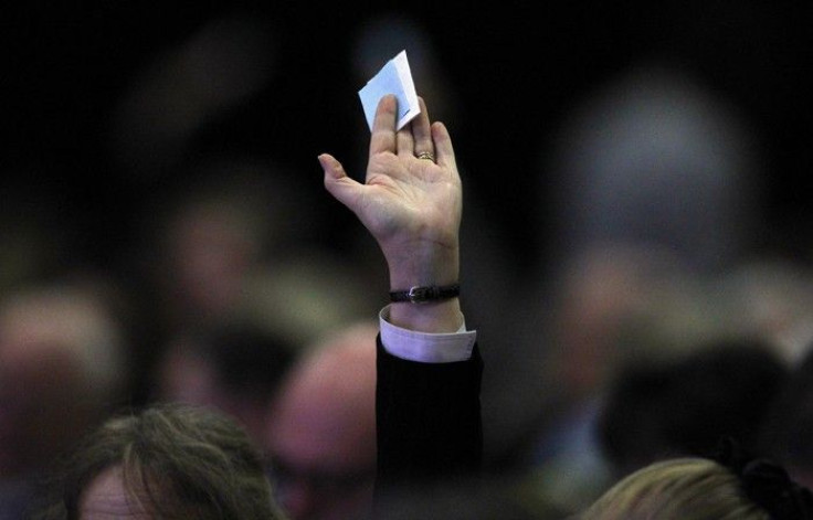A man holds his ballot paper in the air for collection during the federation of small businesses conference in Aberdeen