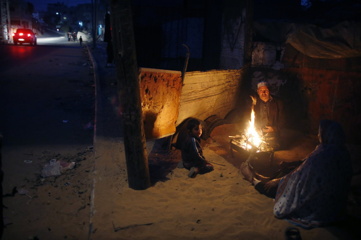 A Palestinian family warm themselves by a fire outside their house during a power cut in the northern Gaza Strip November 17, 2013