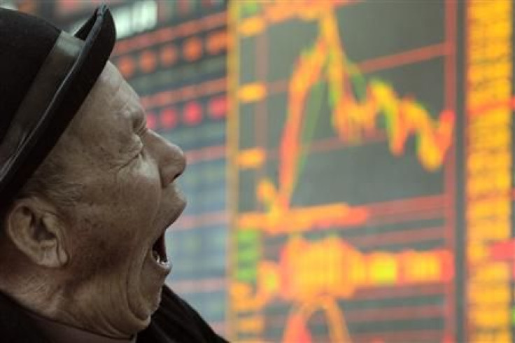 A man yawns in front of an electronic board showing stock information at a brokerage house in Taiyuan, Shanxi province