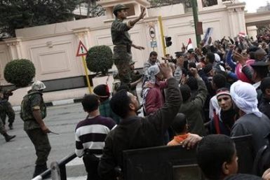 An Egyptian soldier tries to calm opposition supporters outside the Interior Ministry near Tahrir Square in Cairo