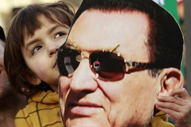 A child holds a mask of Egypt's former President Hosni Mubarak during a rally in Trafalgar Square in central London