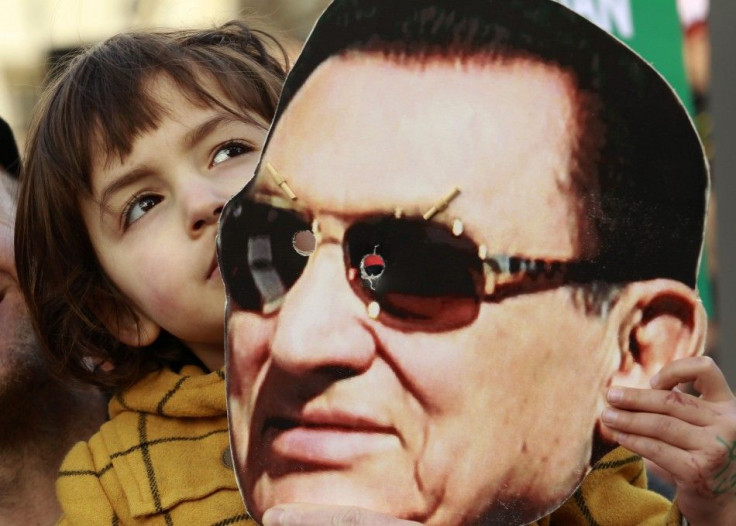 A child holds a mask of Egypt's former President Hosni Mubarak during a rally in Trafalgar Square in central London