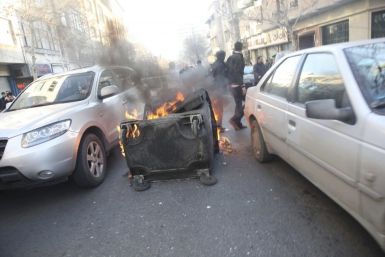A dumpster burns on a street near Azadi Square in Tehran
