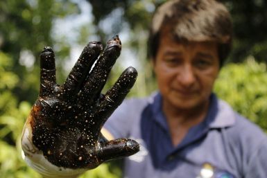 Environmentalist Donald Moncayo shows his glove after conducting a test made on an affected field in Lago Agrio January 25, 2011. Moncayo coordinates visits to the polluted fields involved in the $27 billion suit brought against Chevron Corp by local farm