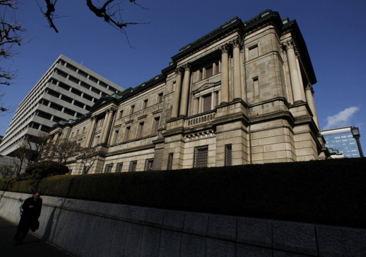 A pedestrian walks past the Bank of Japan (BOJ) headquarters in Tokyo February 15, 2011