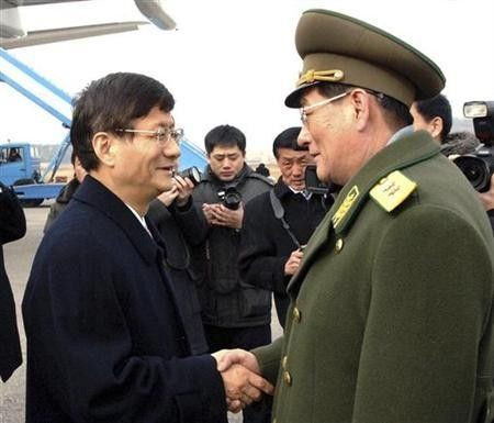 China's public security minister Meng Jianzhu (L) is greeted by North Korean official upon his arrival at an airport in Pyongyang in this picture released by North Korea's official KCNA