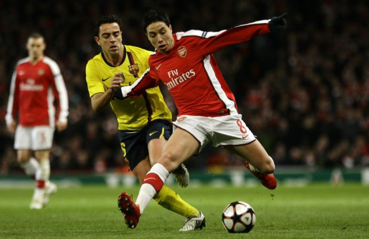 Arsenal's Nasri is challenged by Barcelona's Xavi during their Champions League quarter-final soccer match in London.