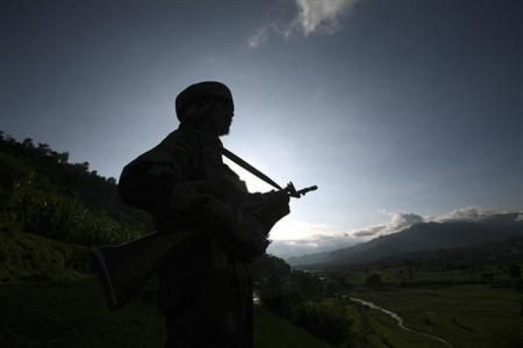 An Indian army soldier stands guard while patrolling near the Line of Control, a ceasefire line dividing Kashmir between India and Pakistan, in Poonch district 