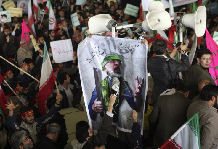 A man uses his shoe to hit a poster of reformist opposition leader Mirhossein Mousavi during the funeral of student Sanea Jaleh in Tehran