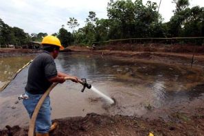 Ecuadorean workers clean up an oil waste pit owned by state petroleum company Petroecuador in Shushufindi, east of Quito, December 8, 2009