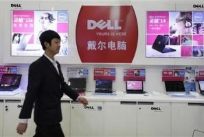 An employee walks past Dell laptops, which are displayed for sale, at a Dell outlet in Beijing