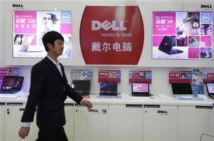 An employee walks past Dell laptops, which are displayed for sale, at a Dell outlet in Beijing