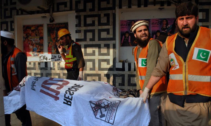Rescue workers remove a body from the site of a grenade attack Shama movie theater in Peshawar, Pakistan