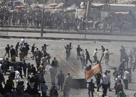 Anti-government protesters (back to the camera) and government backers face each other during clashes in Sanaa