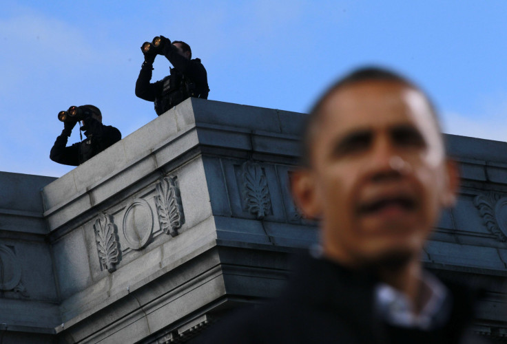 Obama speaks under two counter assault team members