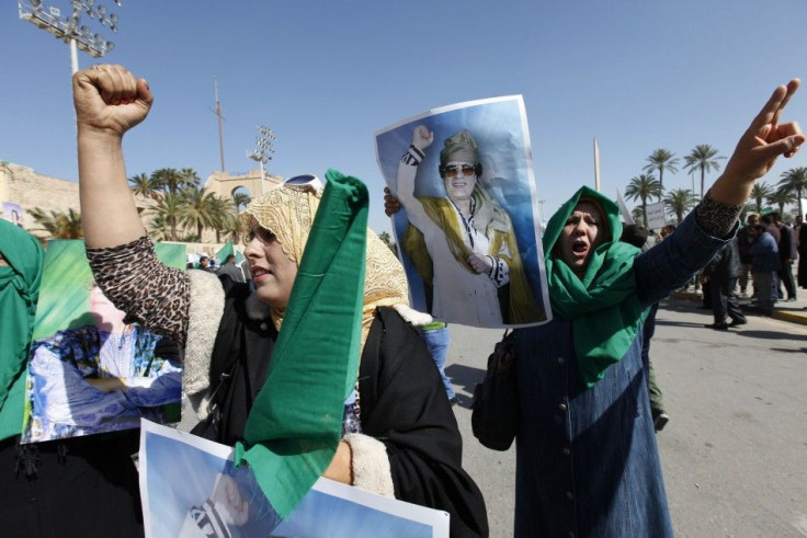 Pro-government supporters hold posters of Libyan leader Gaddafi as they chant slogans during a demonstration in Tripoli