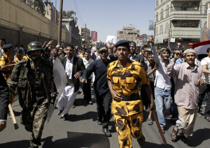 Policemen run after failing to block anti-government protesters during a demonstration in Sanaa