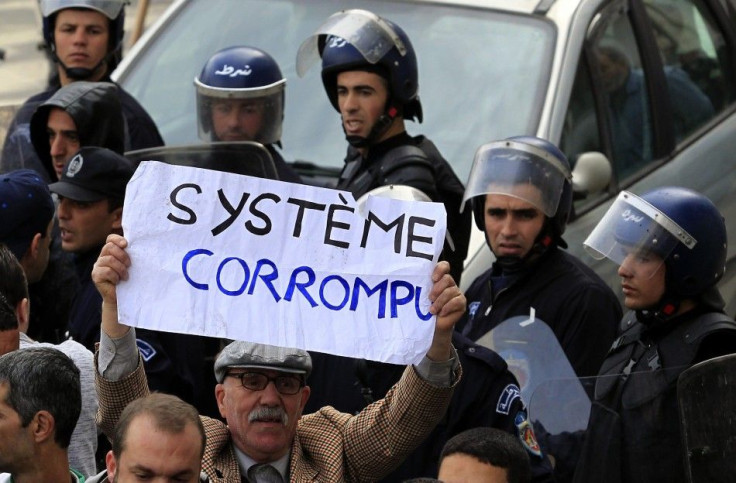 An anti gouvernment protesters holds a sign on which e read &quot;Corrupted system&quot; during a demonstration in Algiers 