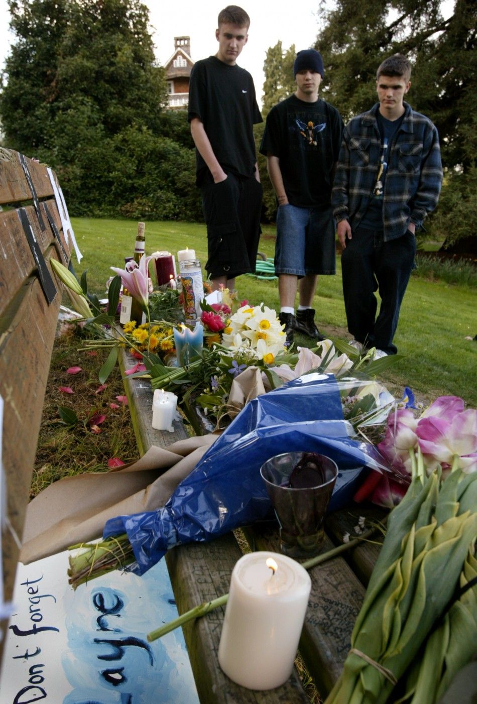 Fans look at an informal memorial of flowers, candles and artwork placed on a park bench at Viretta Park in Seattle, Washington