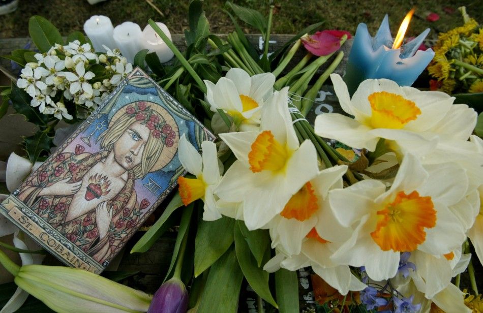 Flowers, candles and artwork commemorating Kurt Cobain are placed on a park bench during an informal memorial at Viretta Park in Seattle, Washington