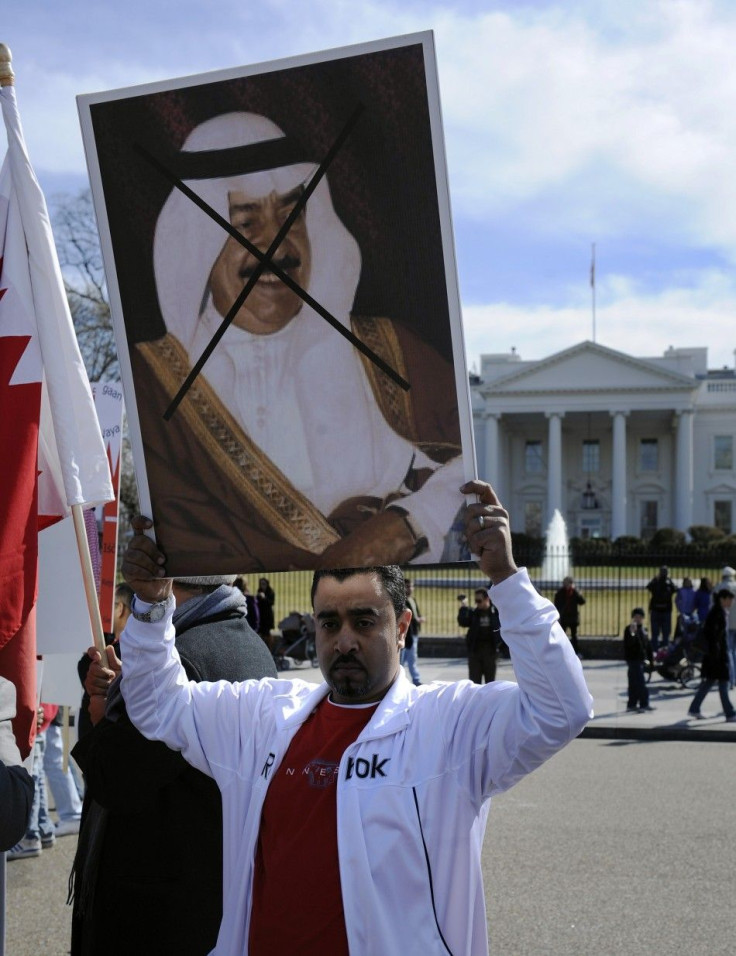 Man holds poster of Bahrain's PM Sheikh Khalifa as demonstrators protest against Bahrain's ruling Al-Khalifa family, in front of White House in Washington