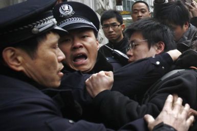A man is arrested by police after internet social networks called to join a 'Jasmine Revolution' protest in front of the Peace Cinema in downtown Shanghai