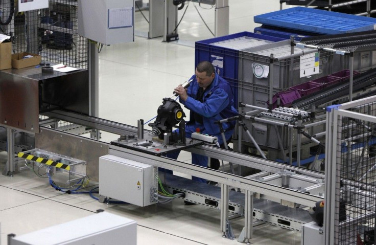 A BMW employee sits on an ergonomically designed chair while working at the new axle gearing production line in Dingolfing