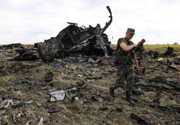 Pro-Russian separatists walk at the site of the crash of the Il-76 Ukrainian army transport plane in Luhansk, June 14, 2014. REUTERS/Shamil Zhumatov