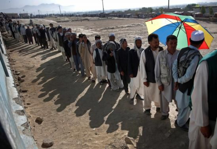 Afghan men line up to cast their votes at a polling station in Kabul June 14, 2014.