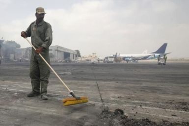   A man clears debris from the tarmac of Jinnah International Airport, after Sunday's attack by Taliban militants on Sunday, in Karachi June 10, 2014.