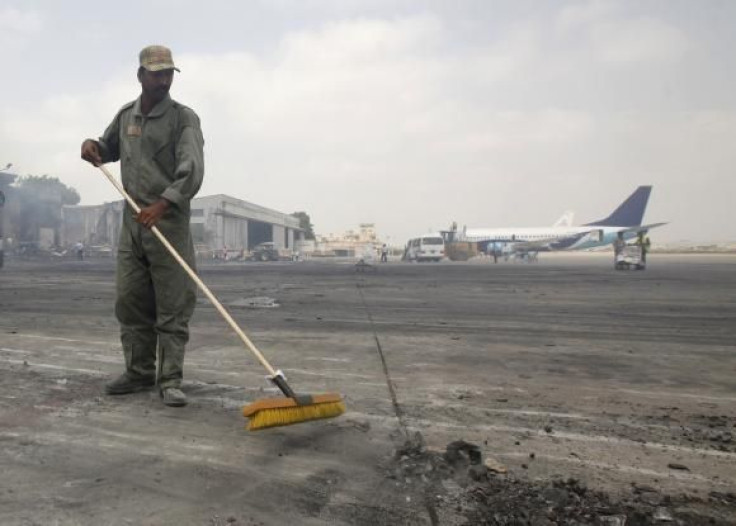   A man clears debris from the tarmac of Jinnah International Airport, after Sunday's attack by Taliban militants on Sunday, in Karachi June 10, 2014.