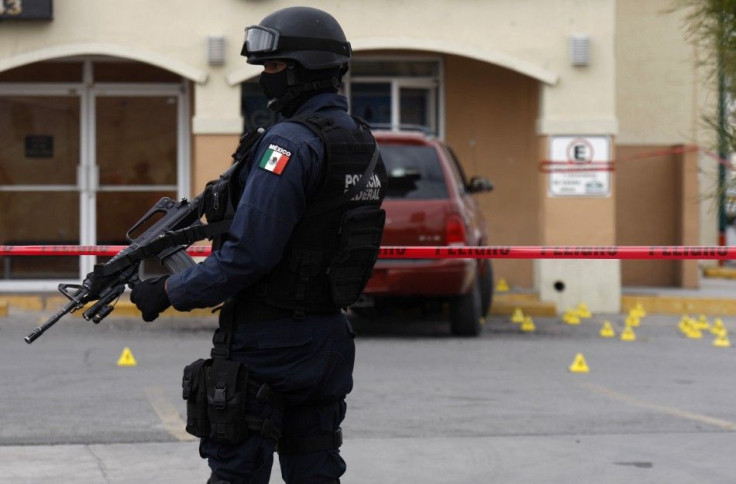 A police officer stands guard at a crime scene where two men were shot dead earlier in Ciudad Juarez