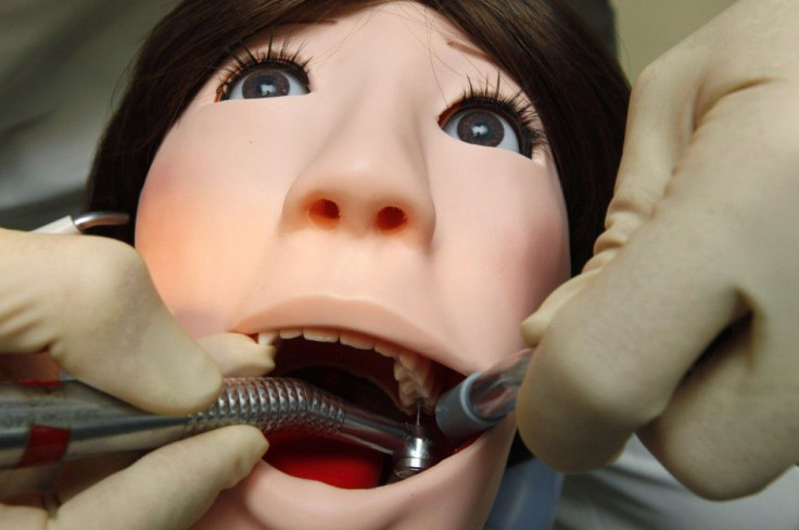 A dentist demonstrates on a dental patient robot at its unveiling ceremony at Showa University in Tokyo