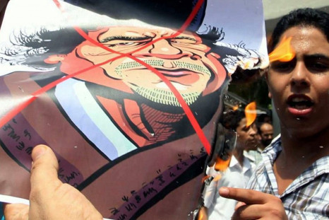 A Libyan living in Malaysia burns a cartoon image of Libyan leader Muammar Gaddafi during a protest in Kuala Lumpur