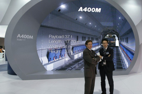 EADS staff stand near a life-size scale display of the interior of the Airbus A400M military transport plane at the Singapore Airshow