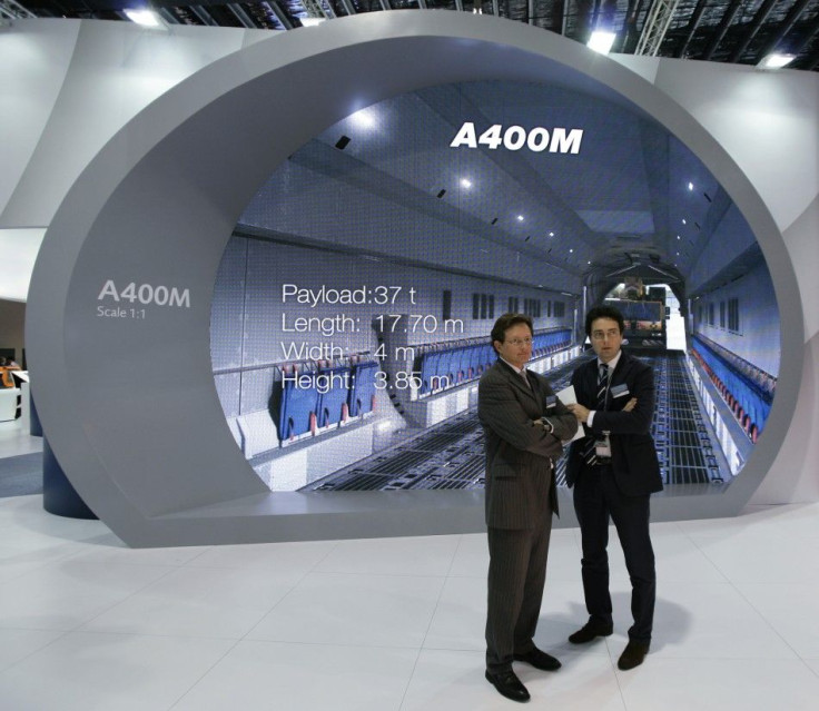 EADS staff stand near a life-size scale display of the interior of the Airbus A400M military transport plane at the Singapore Airshow