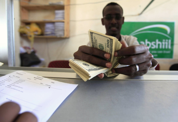 A worker counts U.S. dollars as he serve a customers at a Dahabshiil money transfer office in "Kilometer Five" street of Soobe village, southern Mogadishu