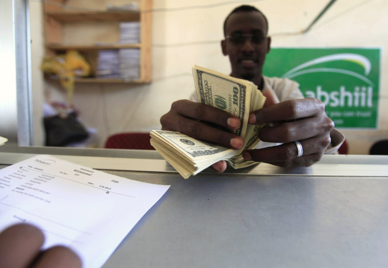 A worker counts U.S. dollars as he serve a customers at a Dahabshiil money transfer office in "Kilometer Five" street of Soobe village, southern Mogadishu