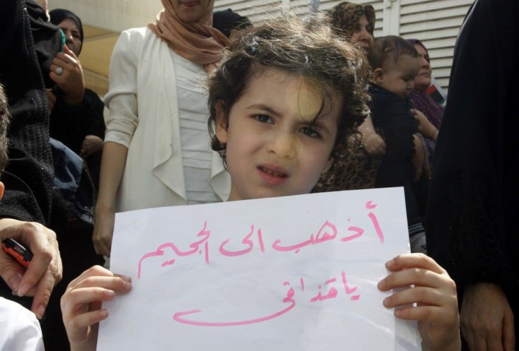 A girl holds a sign during a protest in solidarity with the anti-government protests in Libya, in front of the Libyan consulate in Dubai