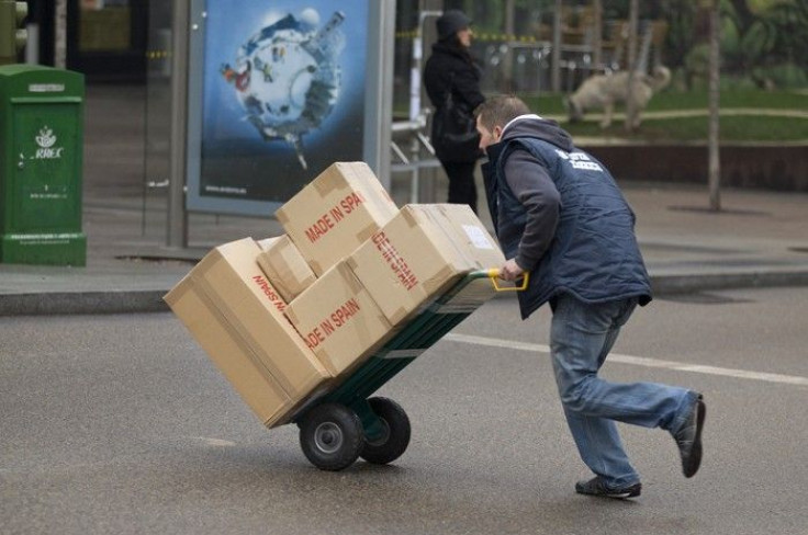 A worker pushes a trolley of boxes in central Madrid