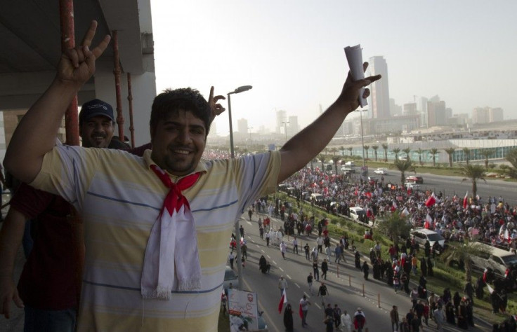 Men flash victory signs as anti-government protesters march towards Pearl Square in Manama