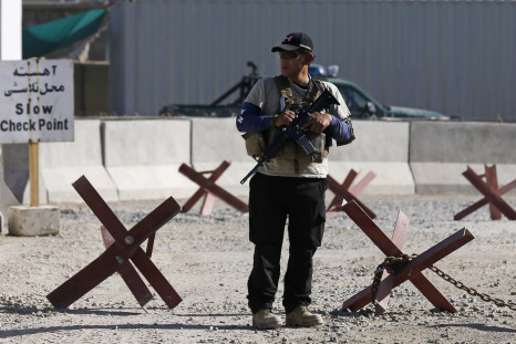 A foreign security contractor from a security company keeps watch at the site of a blast, outside the counter-narcotics office near the Kabul International Airport July 22, 2014 