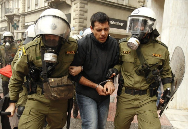 Policemen detain a protester during riots in front of the parliament in Athens
