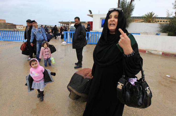 A Tunisian woman reacts as she crosses the border into Tunisia at the border crossing of Ras Jdir after fleeing unrest in Libya