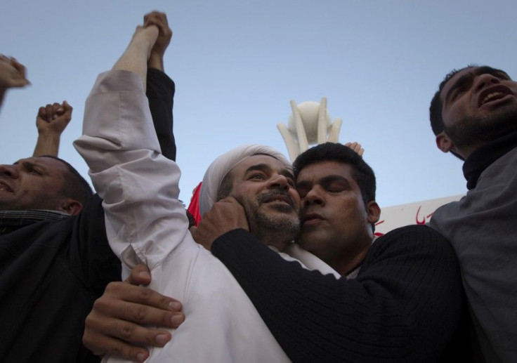 Cleric Sheikh Mohammed Habib Muqdad, on of the prisoners pardoned by Bahrain's King Hamad bin Isa, is kissed by a supporter on the protesters' stage at Pearl Square in Manama