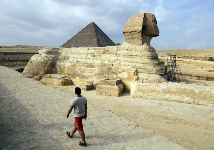 A tourist walks in front of the Great Giza pyramids on the outskirts of Cairo 